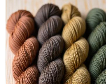 Skeins of organic, naturally dyed yarn in earthy tones, arranged artfully.